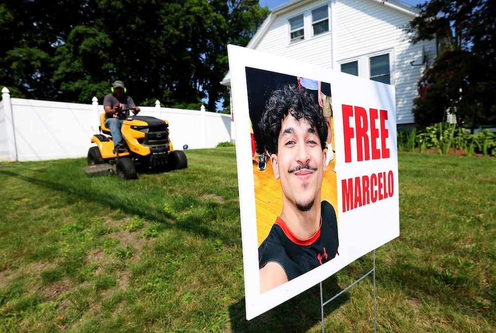A homeowner around a sign supporting Marcelo Gomes Da Silva, who was arrested on his way to...
