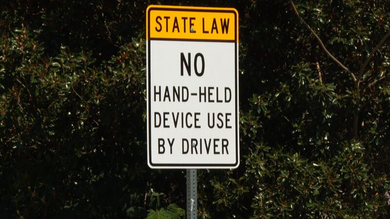 A sign reminding drivers of South Carolina’s new hands-free driving law stands at an entrance...